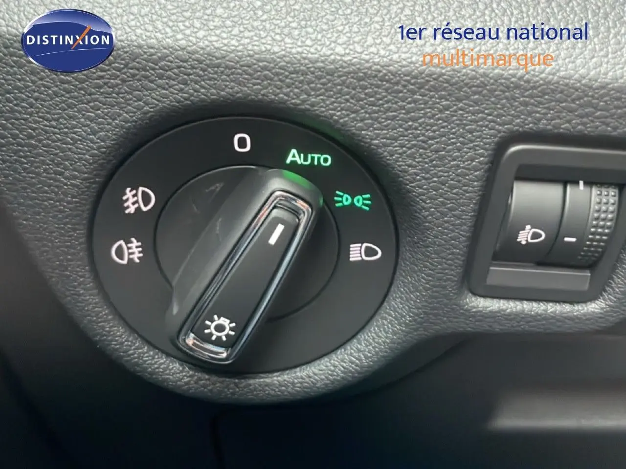 Gros plan sur la molette de réglage des phares du Skoda Kamiq gris graphite, avec fonction automatique activée.