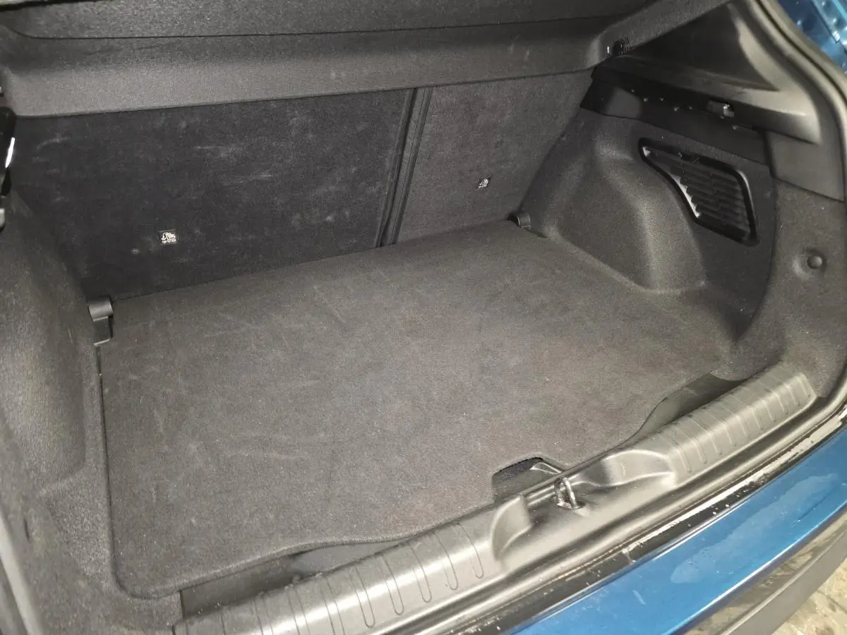 Vue rapprochée du coffre modulable bleu métallisé du FIAT 600 Hybrid 2024, montrant le plancher et les finitions intérieures.