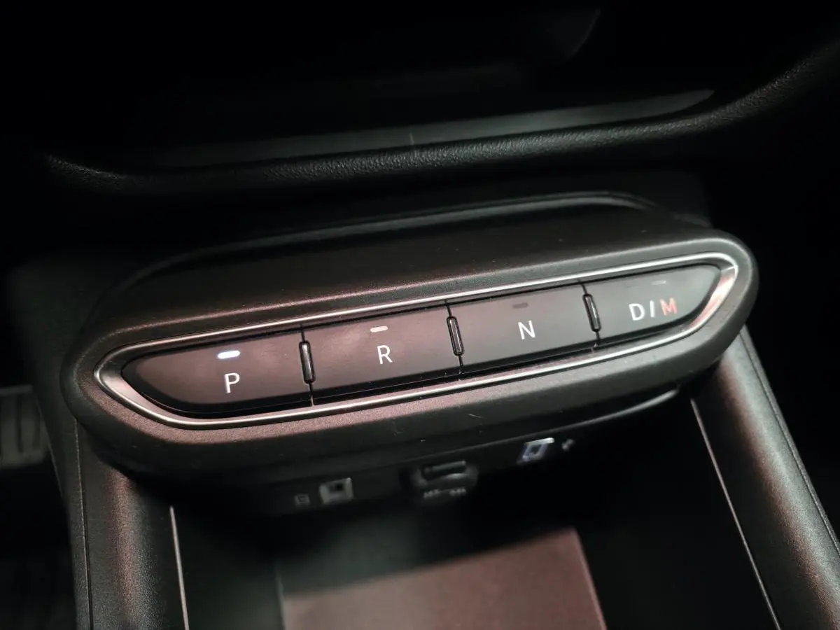 Gros plan sur la commande de boîte automatique noire de la FIAT 600 Hybrid 2024, boutons P, R, N et D/M éclairés.