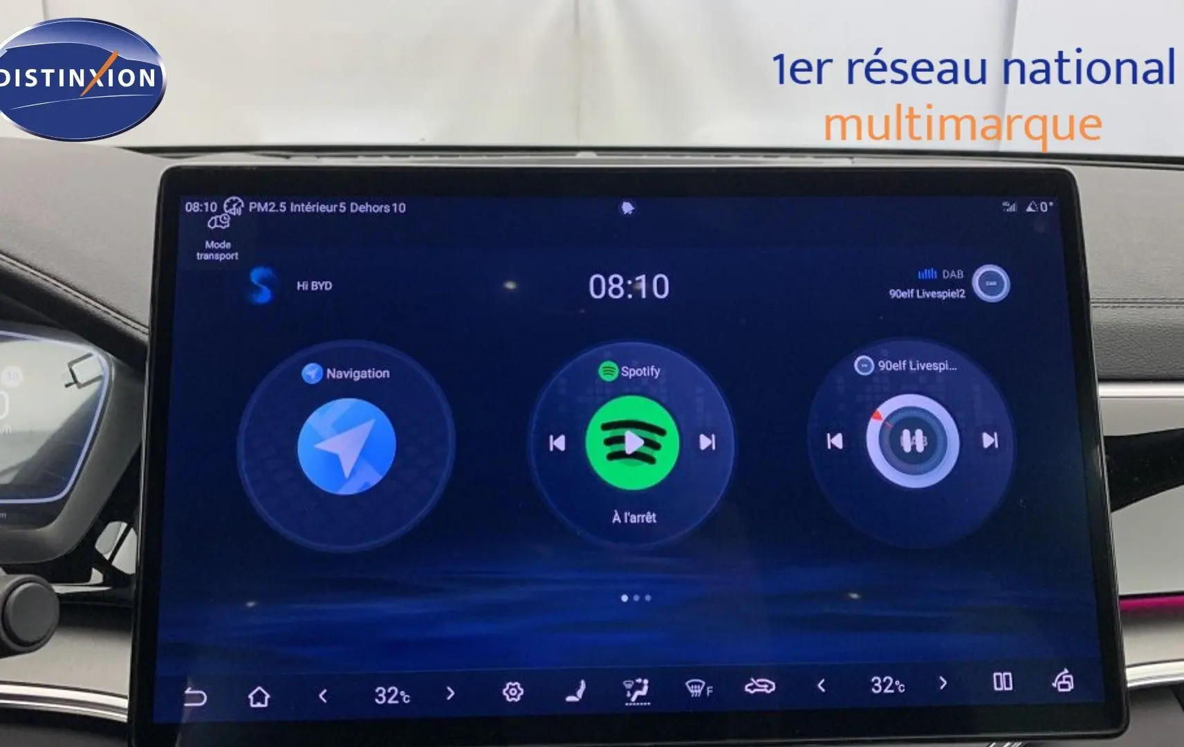 Vue intérieure centrée sur le volant BYD noir avec tableau de bord numérique et écran tactile 15,6 pouces.