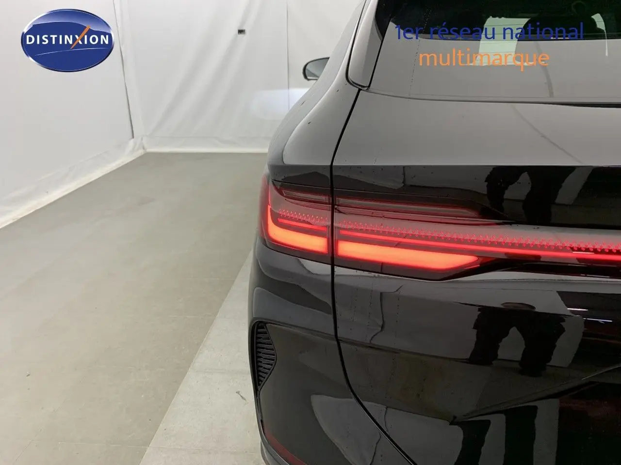 Vue arrière gauche du BYD SEAL U 1.5L DM-I noir obsidian avec feux arrière LED allumés dans un studio.