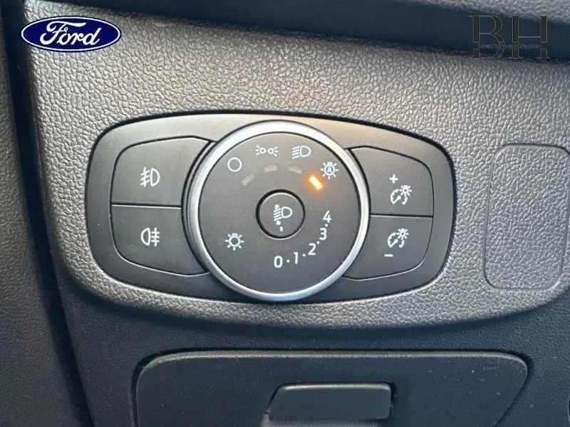 Gros plan sur le bouton de réglage des phares de la Ford Focus 2020, avec éclairage orange actif.