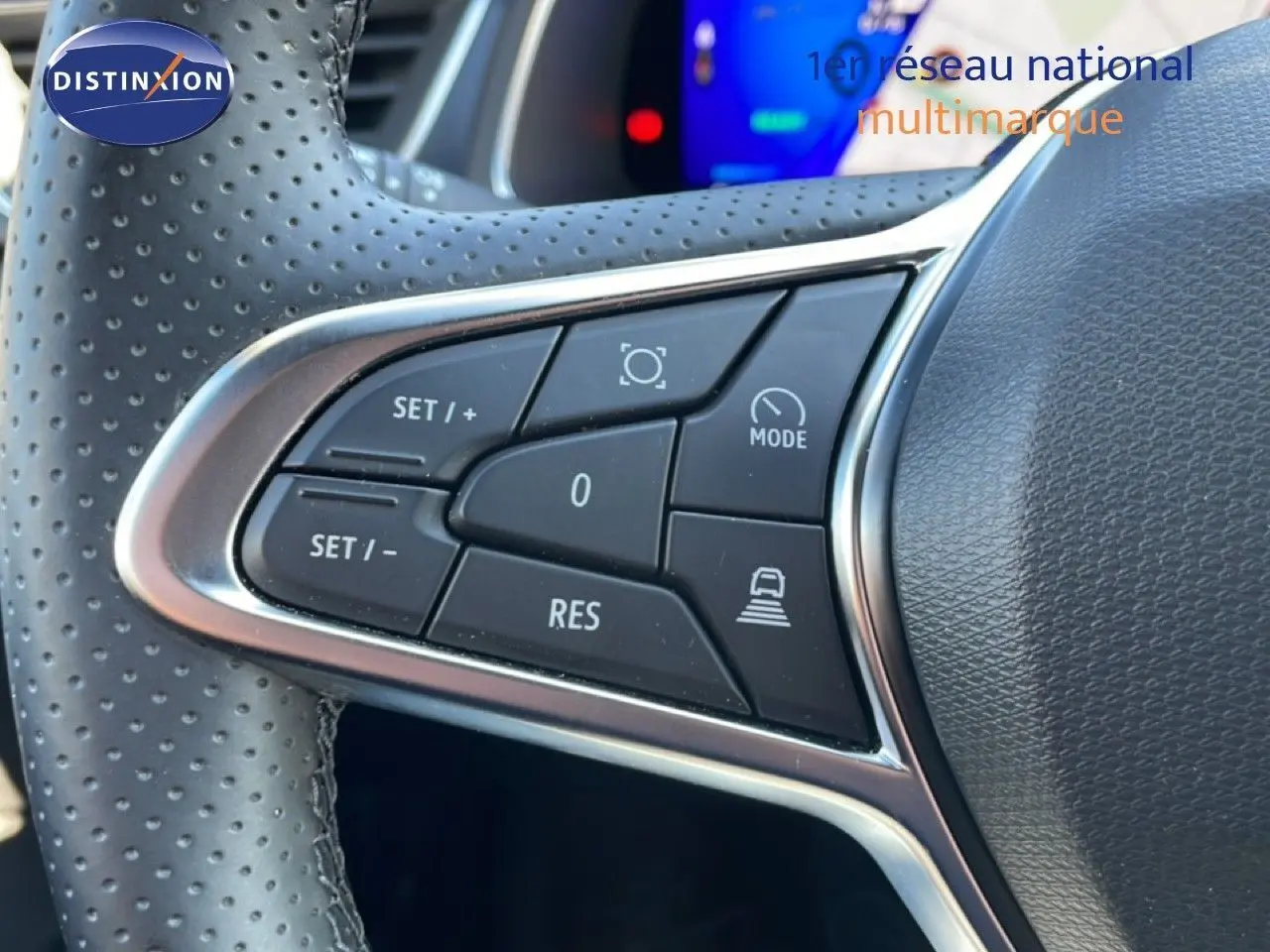 Gros plan sur les commandes à gauche du volant perforé du Renault Symbioz noir étoile métal, version hybride 2025.