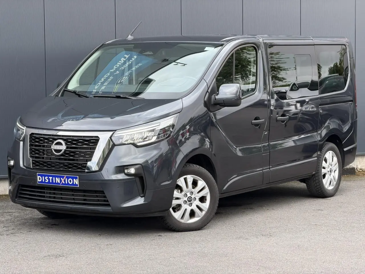 Vue 3/4 avant droit du Nissan Primastar Combi gris Comète avec hayon vitré et jantes alliage 17 pouces.