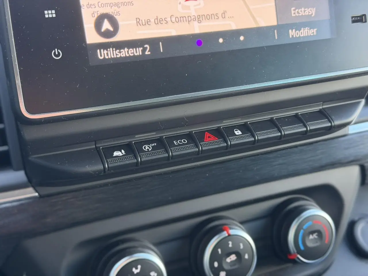Gros plan sur la console centrale du Nissan Primastar Combi 2025, boutons de contrôle et écran tactile visibles.