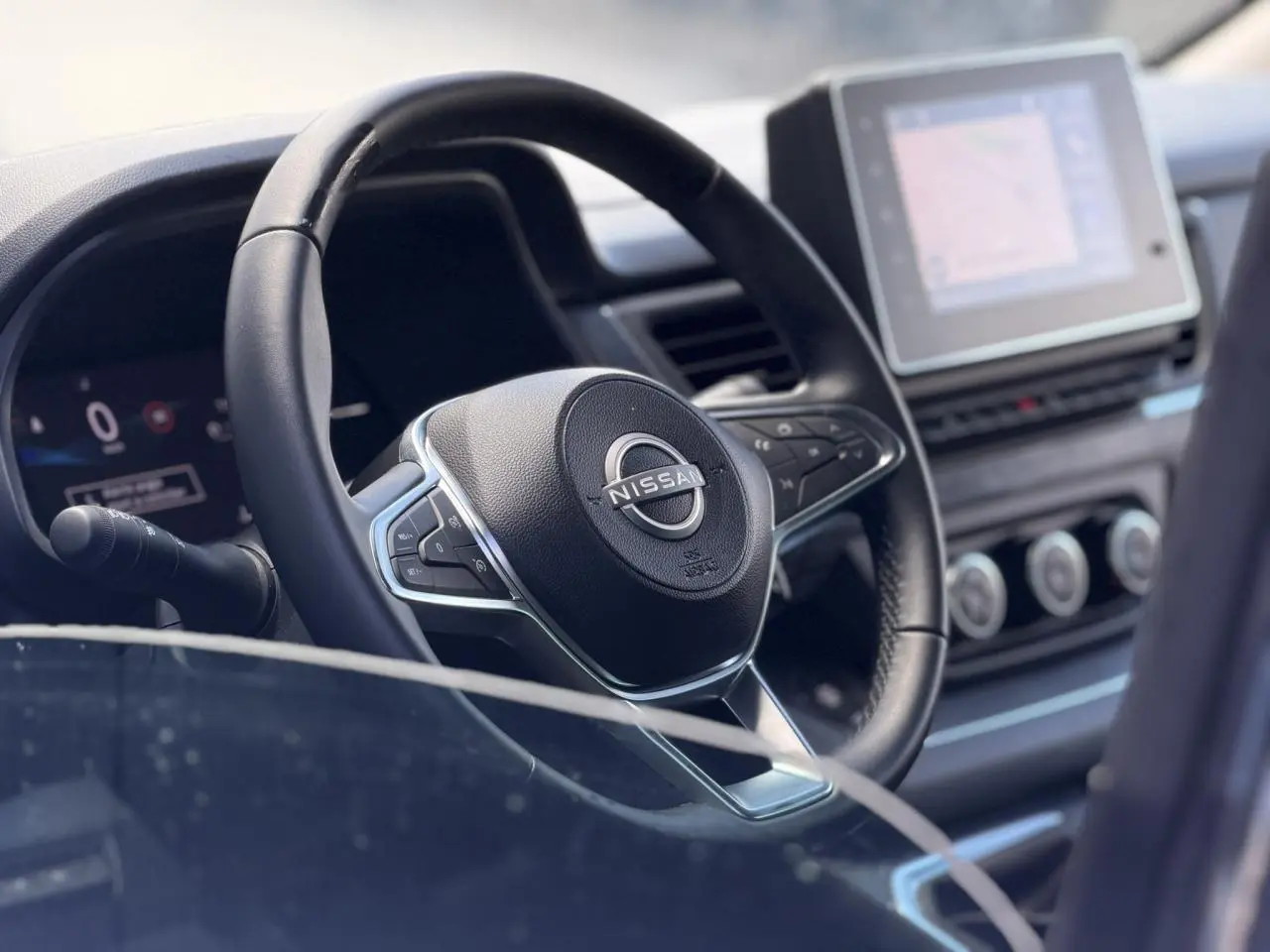 Vue rapprochée du volant noir et du tableau de bord avec écran tactile du Nissan Primastar Combi 2025.
