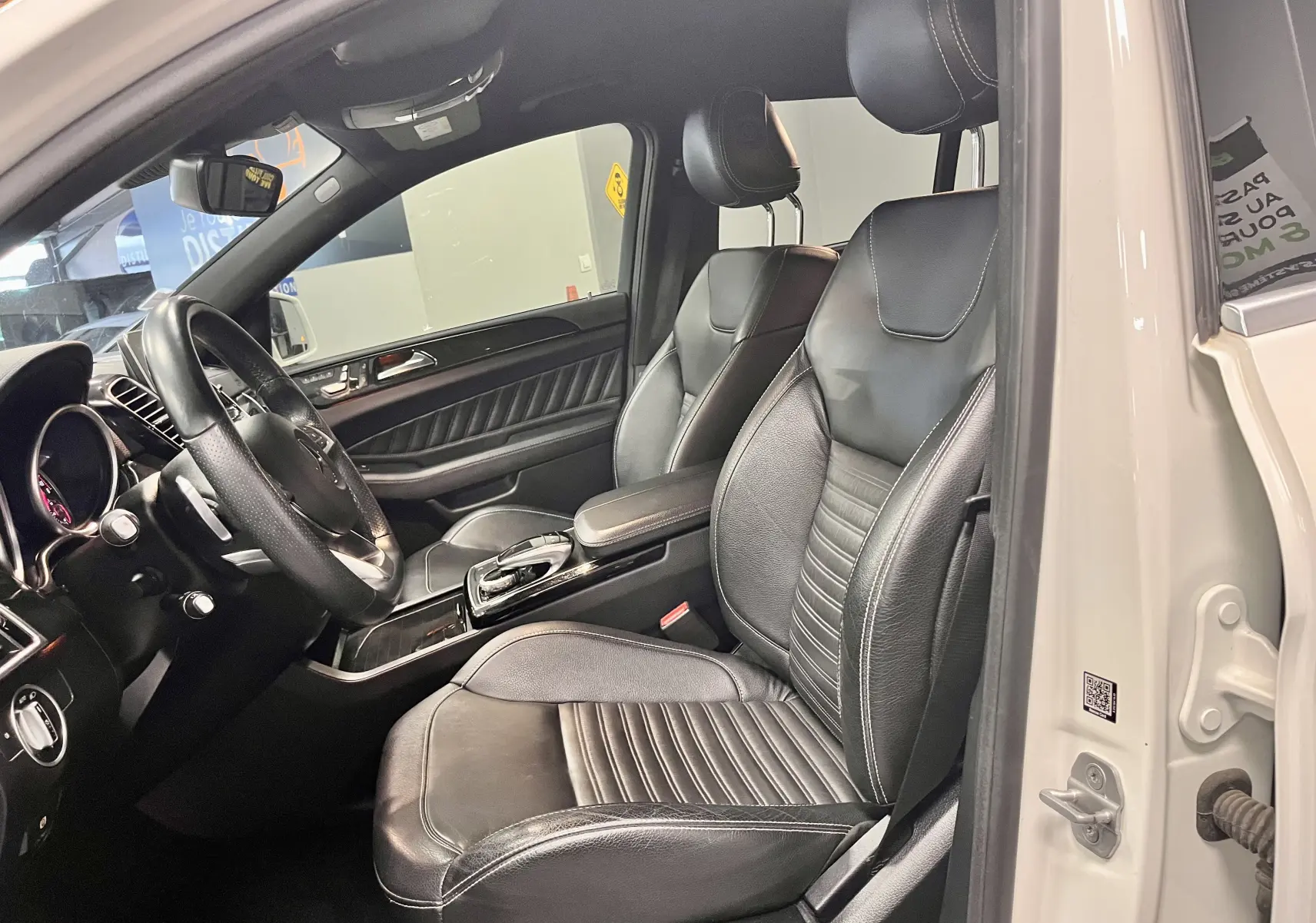 Vue intérieure côté conducteur du Mercedes GLE Coupe 350 d 2016 avec sièges cuir noirs et tableau de bord élégant.