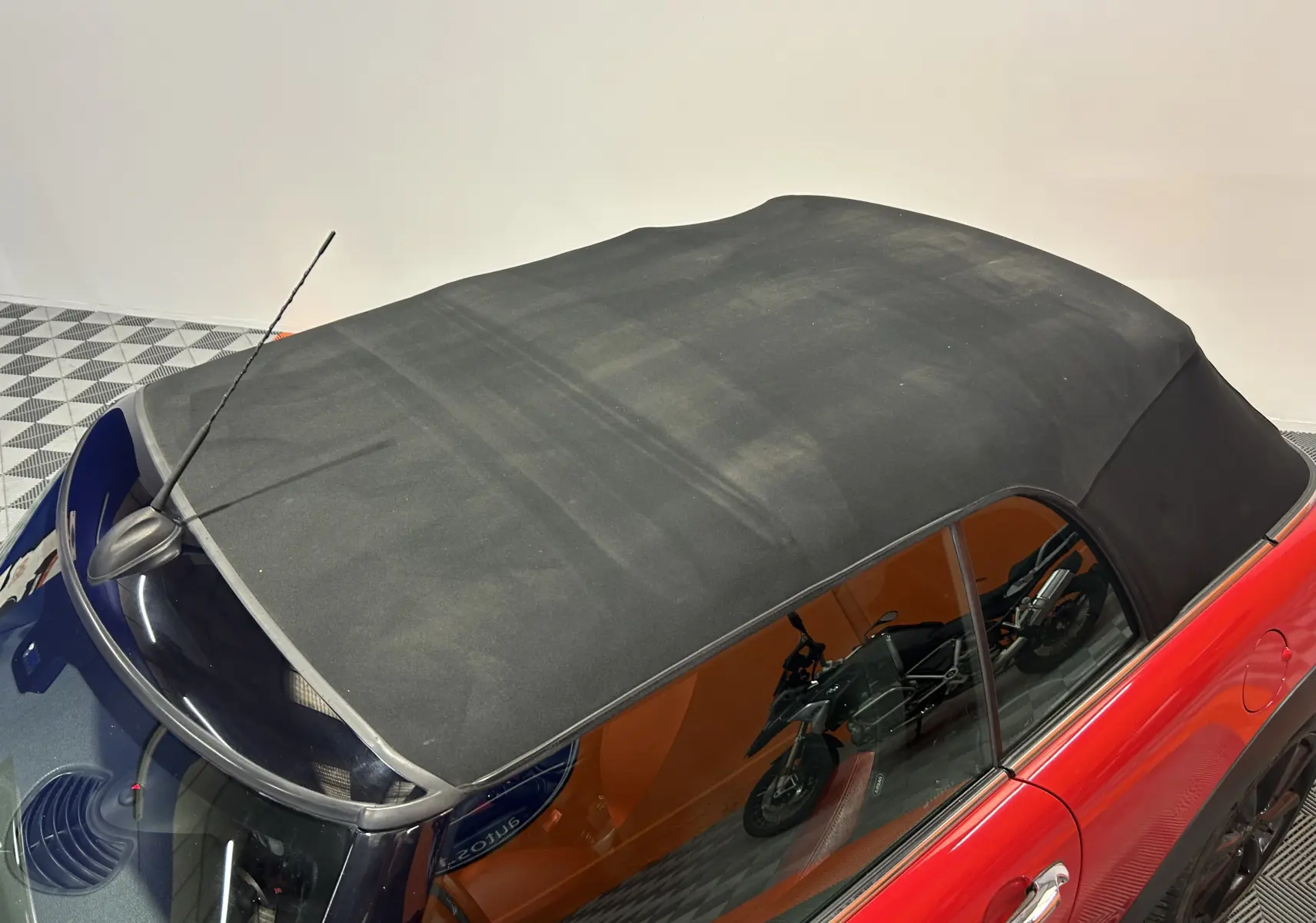 Accoudoir central noir en cuir avec siège bicolore rouge et noir d'une MINI Cabriolet Cooper S 2012.