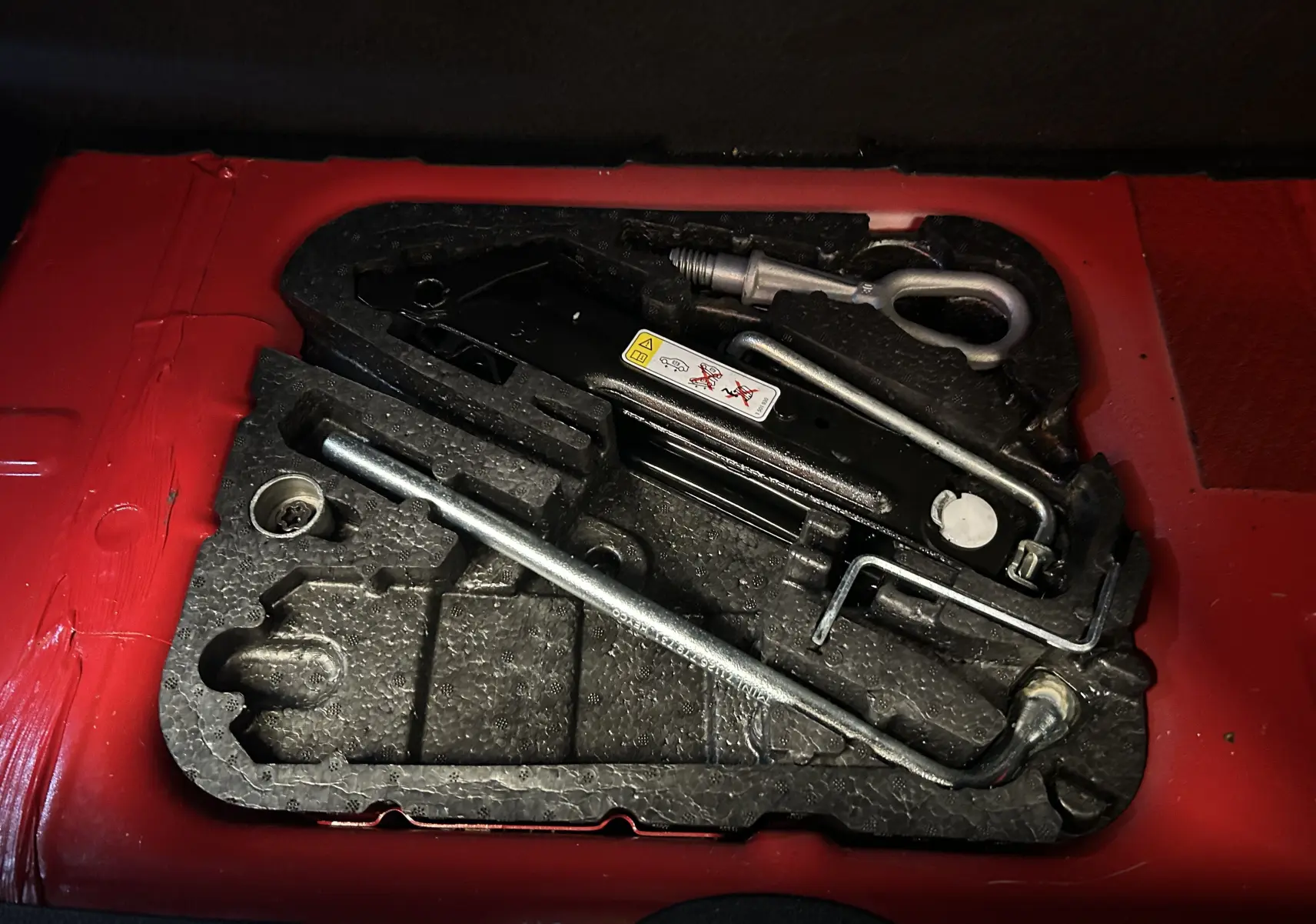 Coffre ouvert vu de l'arrière d'une MINI Cabriolet Cooper S rouge de 2012 avec capote noire.