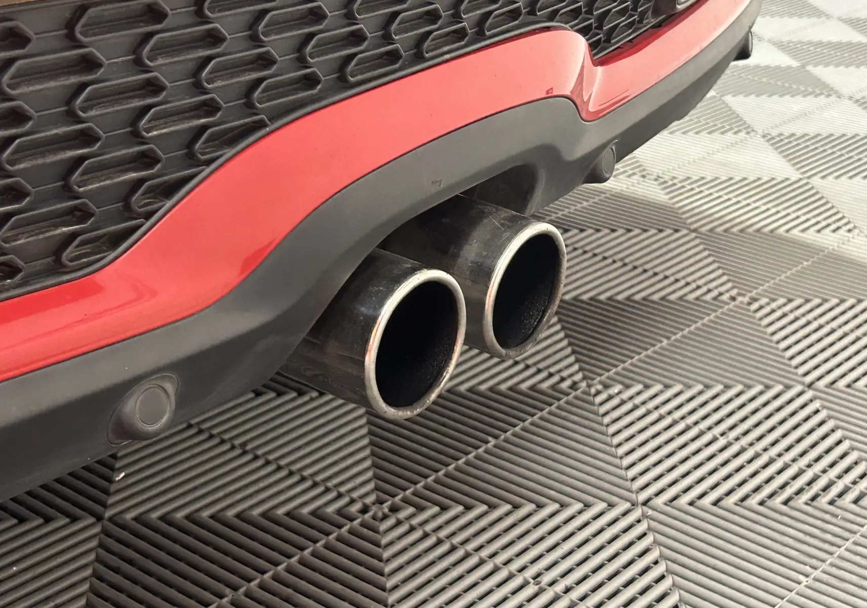 Gros plan sur le phare avant droit d'une MINI Cabriolet Cooper S rouge de 2012, mettant en valeur le design lumineux distinctif.