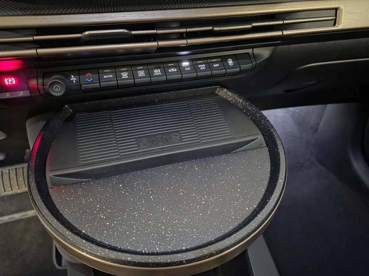 Détail de la console centrale de la Lancia Ypsilon 2025 avec chargeur à induction et commandes climatisation.