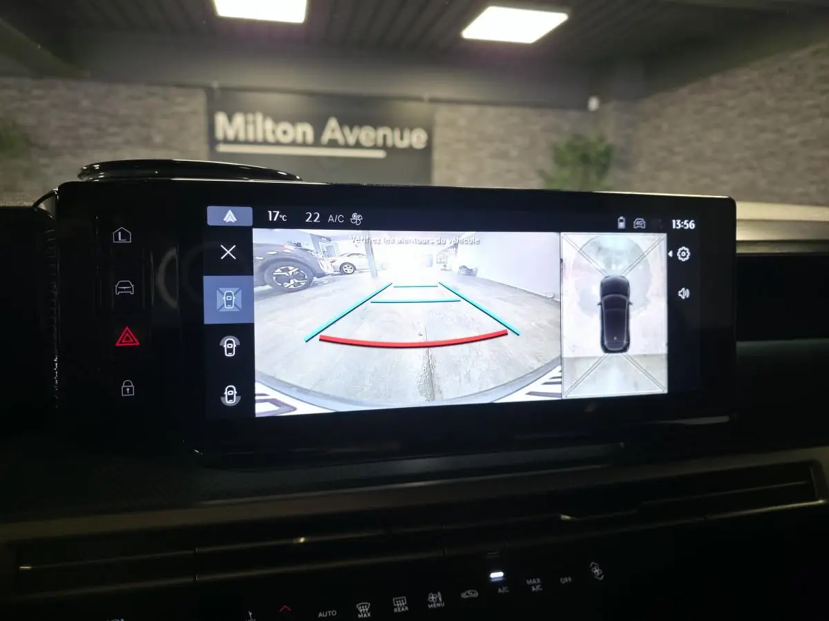 Écran tactile central affichant la caméra de recul et vue 360° d'une Lancia Ypsilon grise bi-color toit noir.