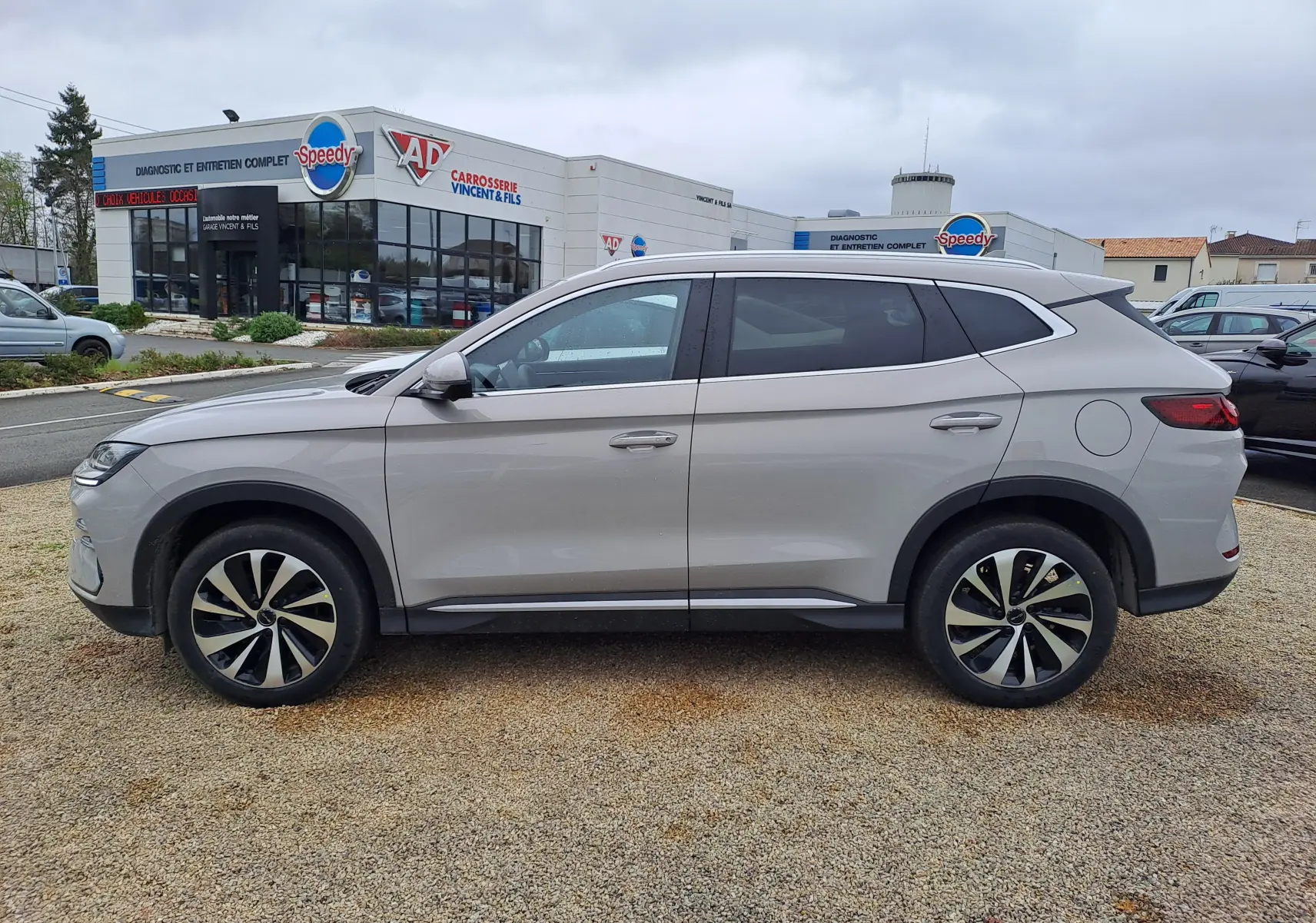 Vue de profil côté gauche du SUV BYD SEAL U 2025 en couleur gris clair Boundless Cloud avec jantes bicolores.