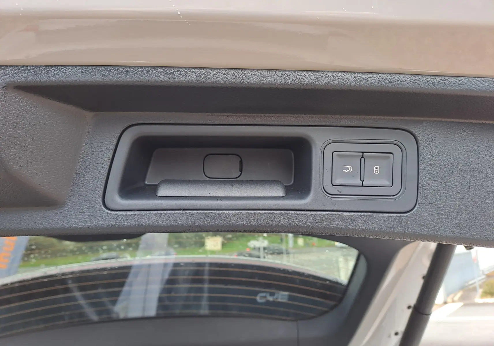 Gros plan sur la poignée intérieure et les boutons de verrouillage du hayon du BYD SEAL U couleur Boundless Cloud.