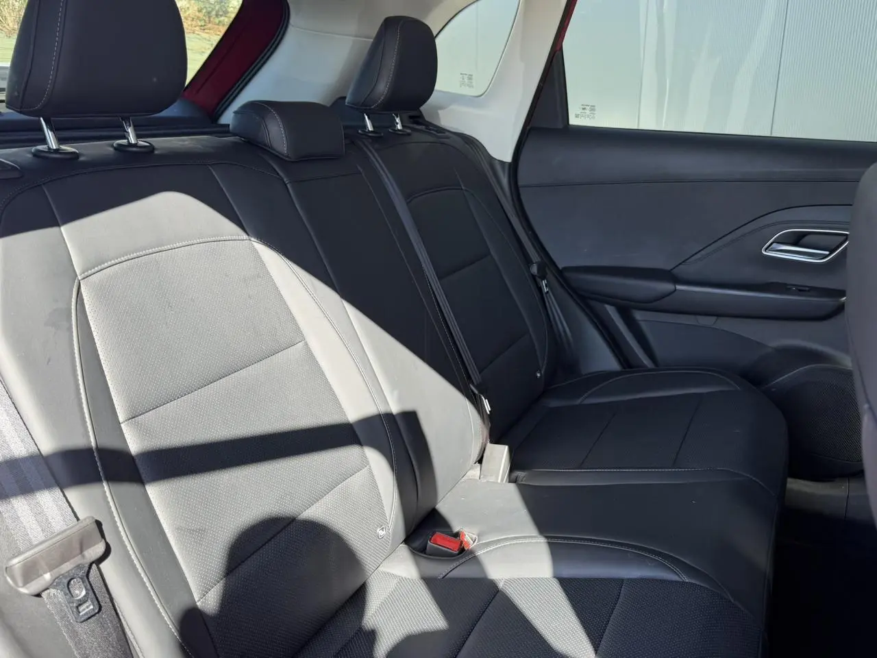 Vue latérale droite de la banquette arrière noire en tissu et similicuir du MG ZS 1.5 Hybrid+ 197 Luxury 2025 Rouge Diamond.