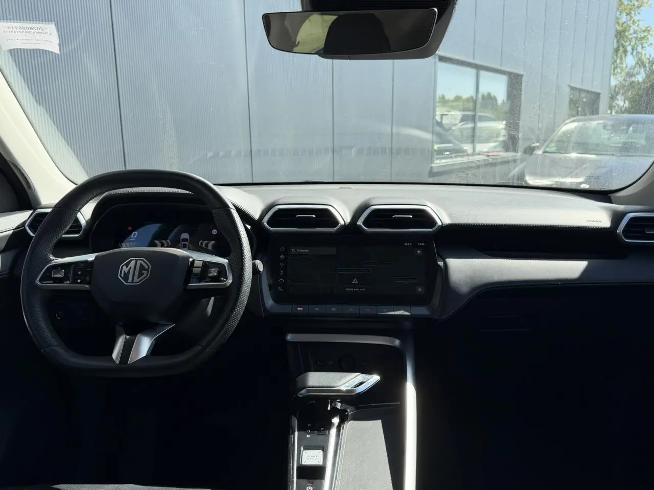 Vue intérieure avant du MG ZS 1.5 Hybrid+ 197 Luxury, tableau de bord noir avec écran tactile et volant multifonction.