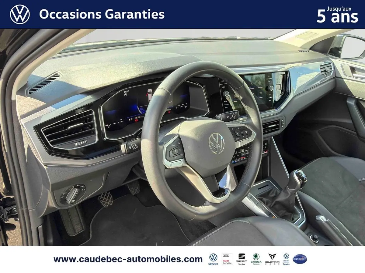 Vue intérieure de face du poste de conduite de la Volkswagen Polo 2025 avec volant cuir et boîte manuelle.