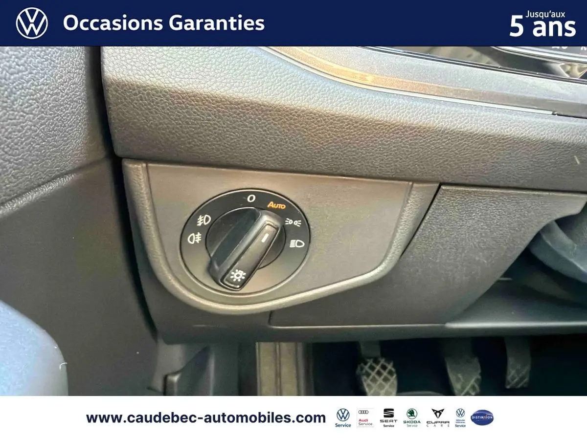Détail du bouton de commande des phares sur le tableau de bord d’une Volkswagen Polo noire intense nacrée.