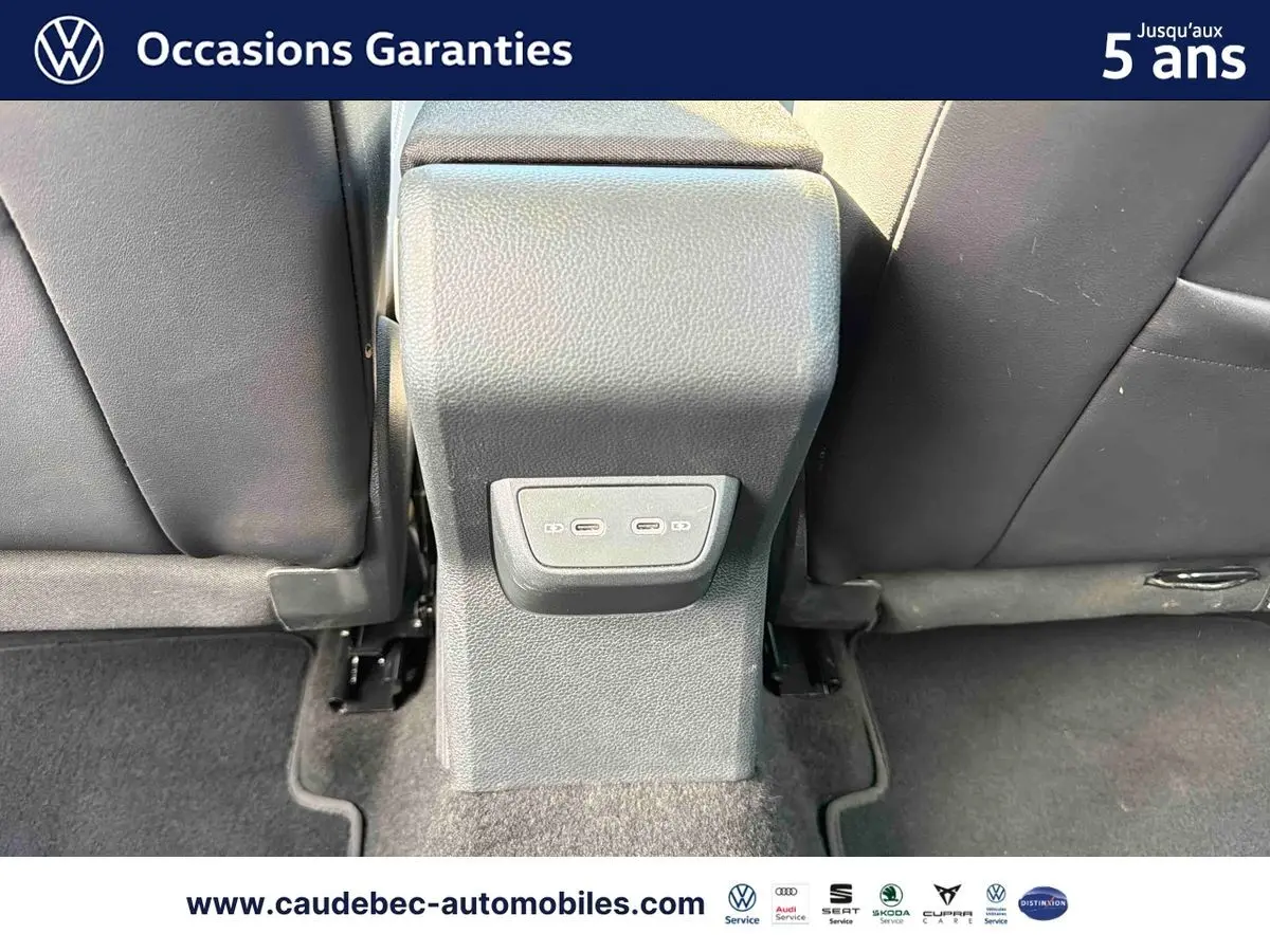Vue rapprochée de la console centrale arrière avec deux ports USB-C entre les sièges noirs du Volkswagen Polo noir intense nacré.