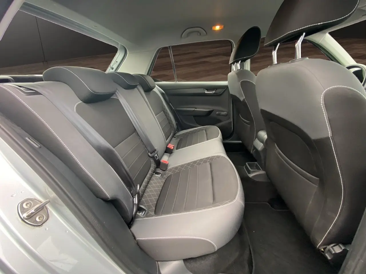 Vue intérieure arrière côté gauche montrant les sièges tissu gris et noir de la Skoda Fabia 2021 finition Ambiente.