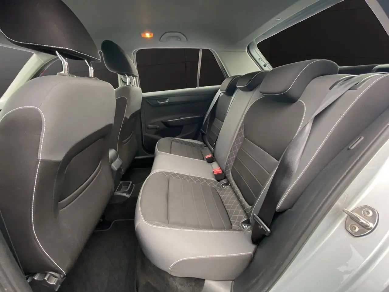 Vue intérieure arrière côté droit montrant les sièges tissu gris et noir de la Skoda Fabia 2021 gris argent.