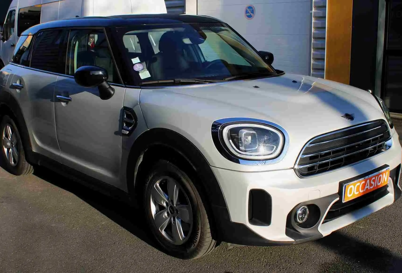 MINI Countryman gris perle avec toit noir, vue 3/4 avant droit, calandre et phares LED visibles.