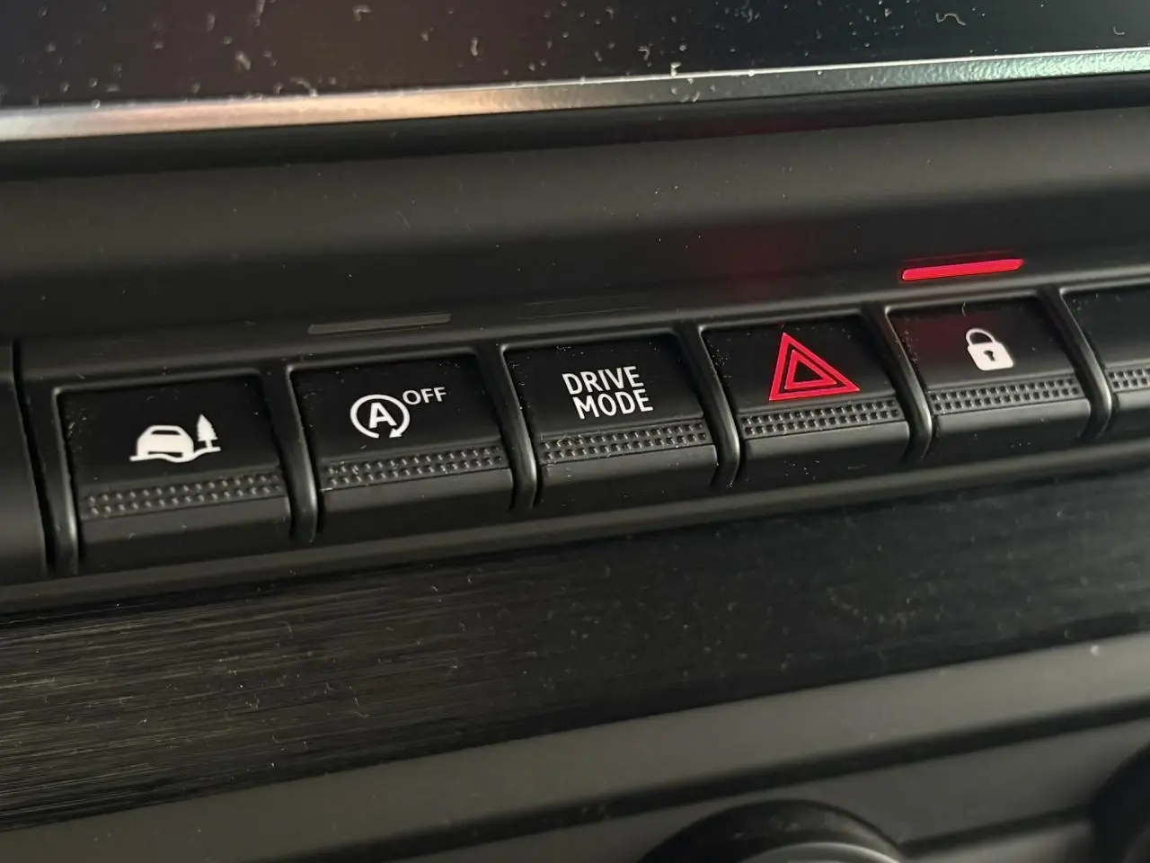 Gros plan sur les boutons de commande du tableau de bord du Nissan Primastar gris, avec mode conduite et alerte.