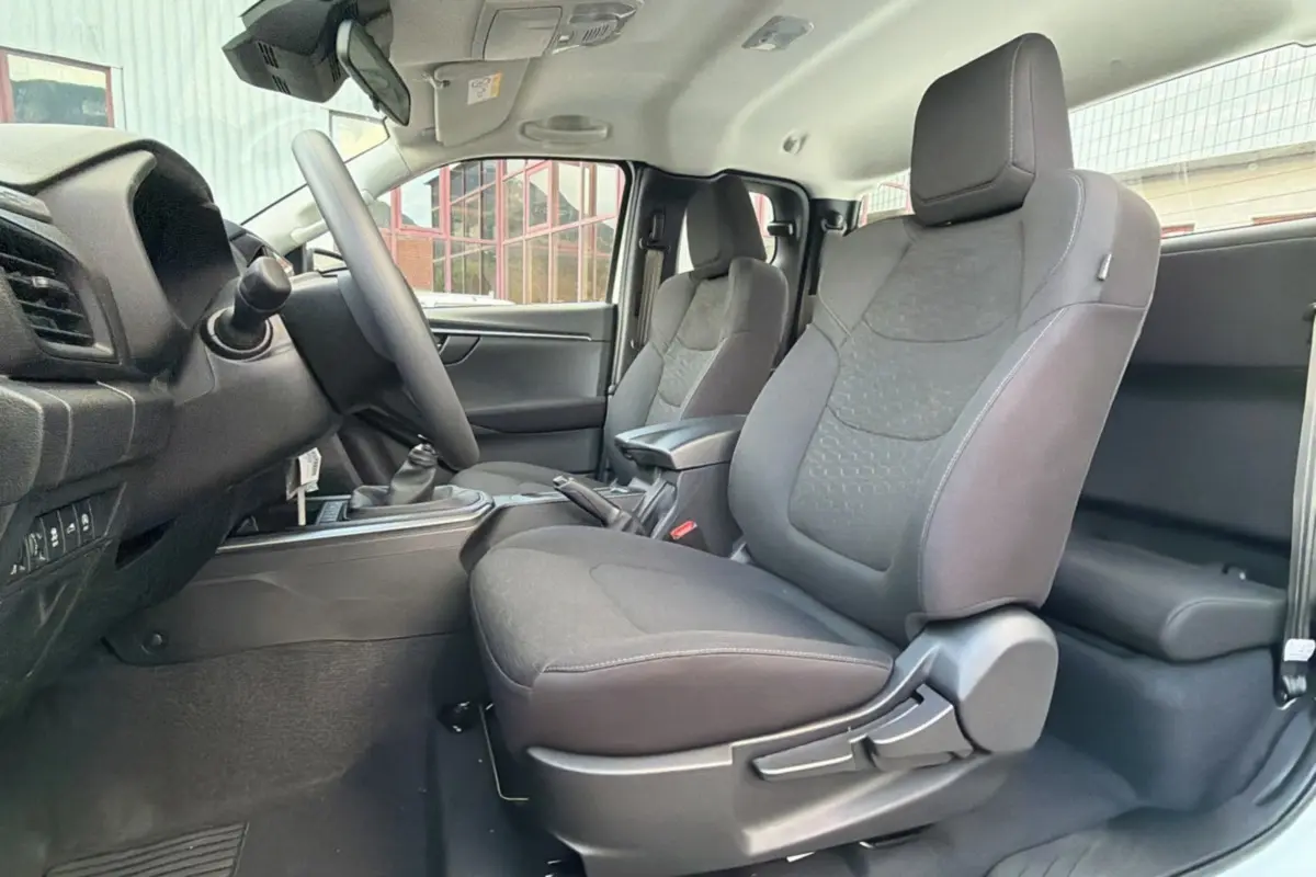 Vue intérieure côté gauche des sièges avant tissu gris foncé de l'Isuzu D-MAX 2026 avec accoudoir central.