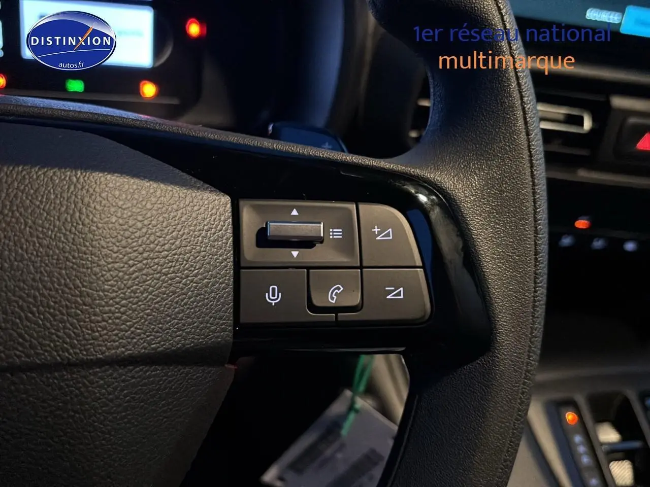 Gros plan sur le volant multifonction noir du Citroën Berlingo Fourgon blanc, avec commandes audio et téléphone visibles.
