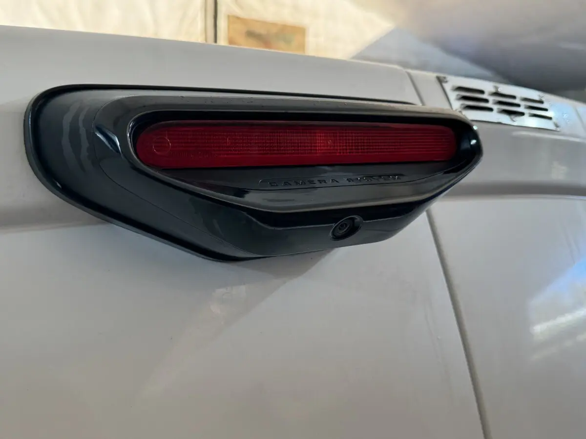 Gros plan sur le feu stop arrière avec caméra intégrée du Citroën Berlingo blanc, vue de côté droit.