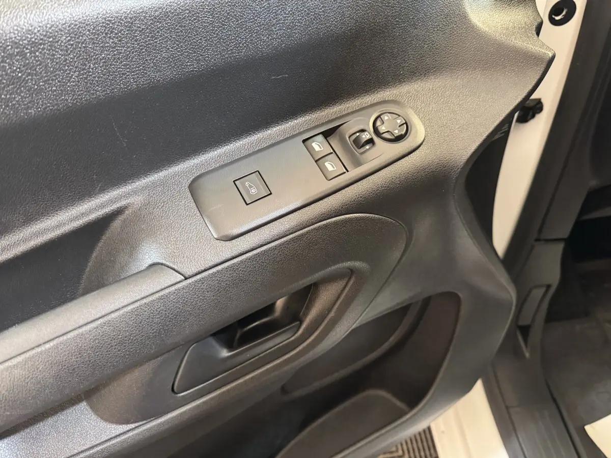 Gros plan sur la porte avant gauche noire avec commandes électriques sur un Citroën Berlingo blanc 2020.