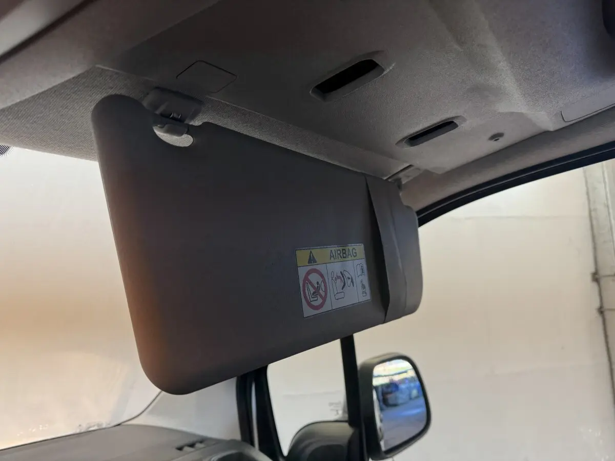 Détail du pare-soleil côté conducteur avec avertissement airbag, intérieur gris du Citroën Berlingo blanc 2020.