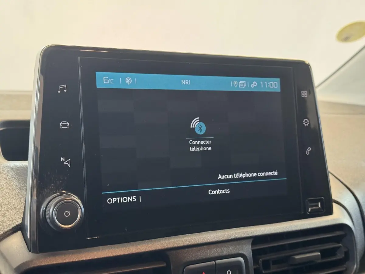 Écran tactile central du tableau de bord du Citroën Berlingo blanc, affichant la connexion Bluetooth au téléphone.