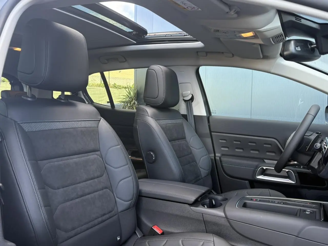 Vue intérieure avant du Citroën C5 Aircross 2025 avec sièges Urban Black en Alcantara noir et toit ouvrant panoramique.