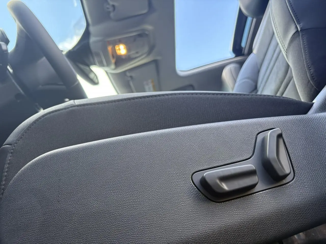 Détail du côté gauche du siège avant noir Alcantara avec commandes électriques dans l'habitacle du Citroën C5 Aircross.