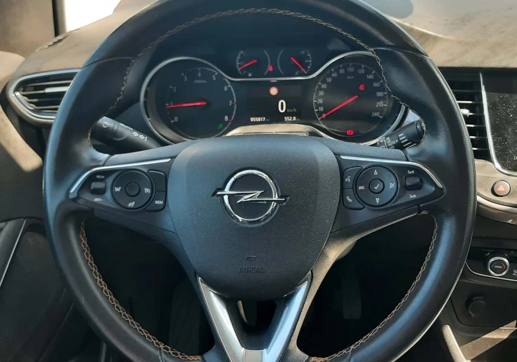 Vue intérieure avant centrée sur le volant noir et la console centrale d'une Opel Crossland X 130ch Innovation 2019.