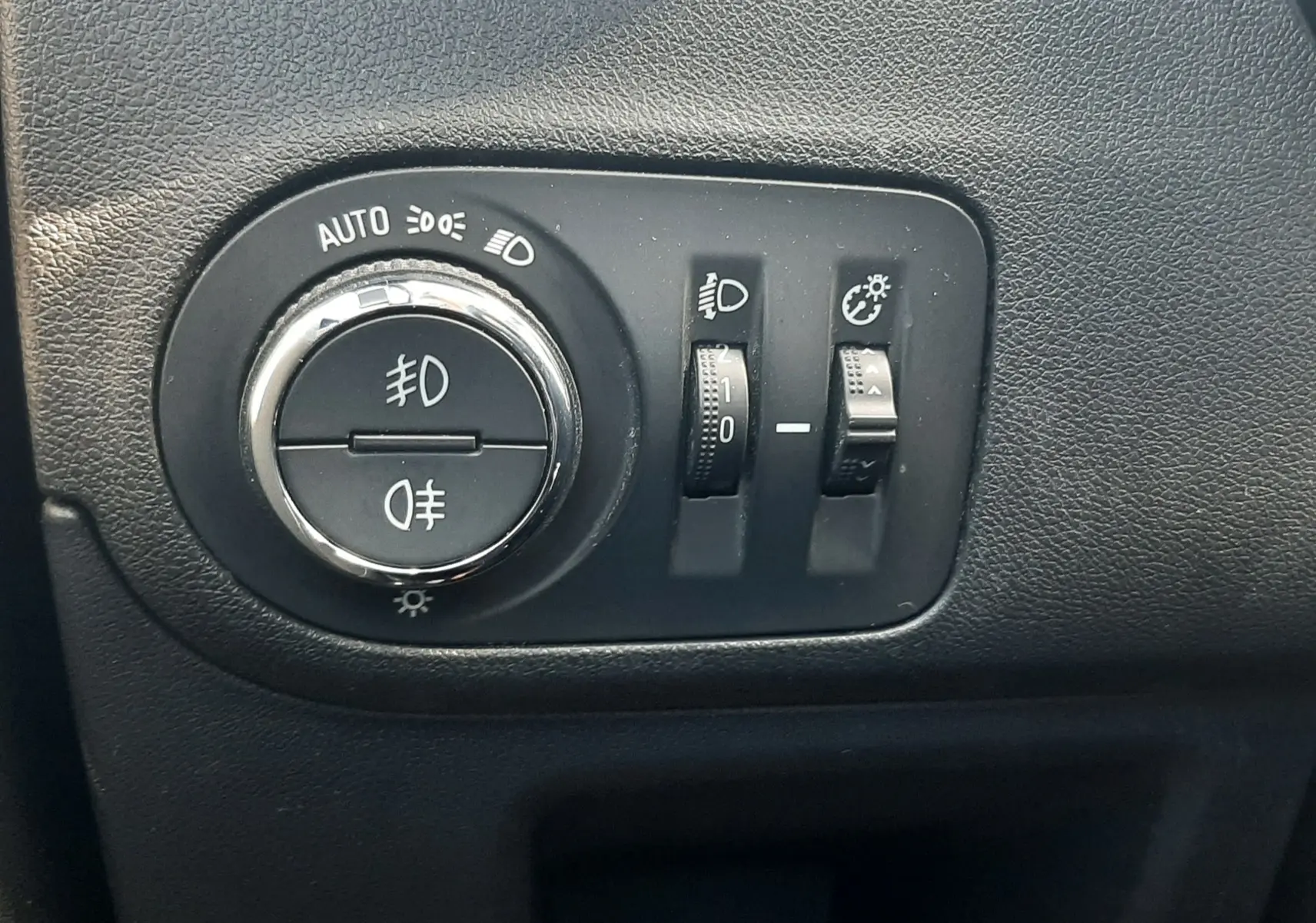 Gros plan sur les commandes des vitres et rétroviseurs côté conducteur de l'Opel Crossland noir avec toit blanc.