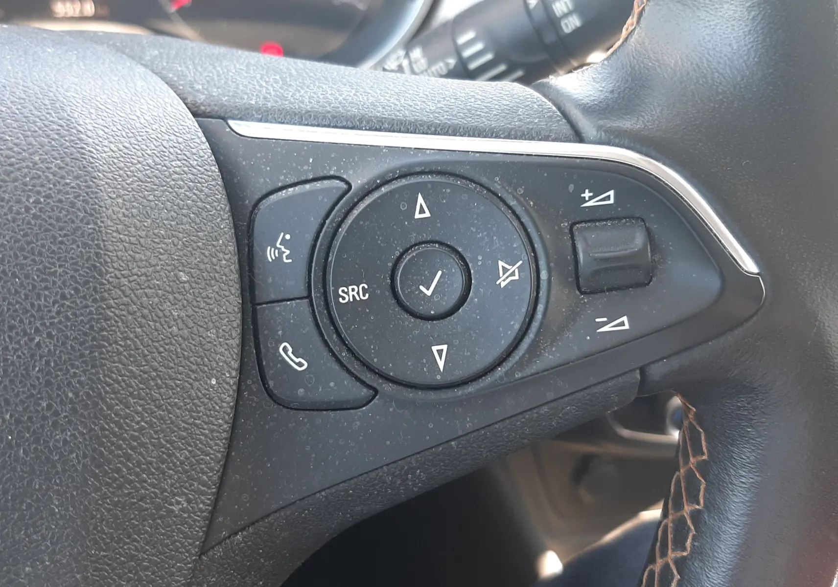 Gros plan sur les commandes de régulateur de vitesse au volant en cuir noir de l'Opel Crossland noir toit blanc 2019.