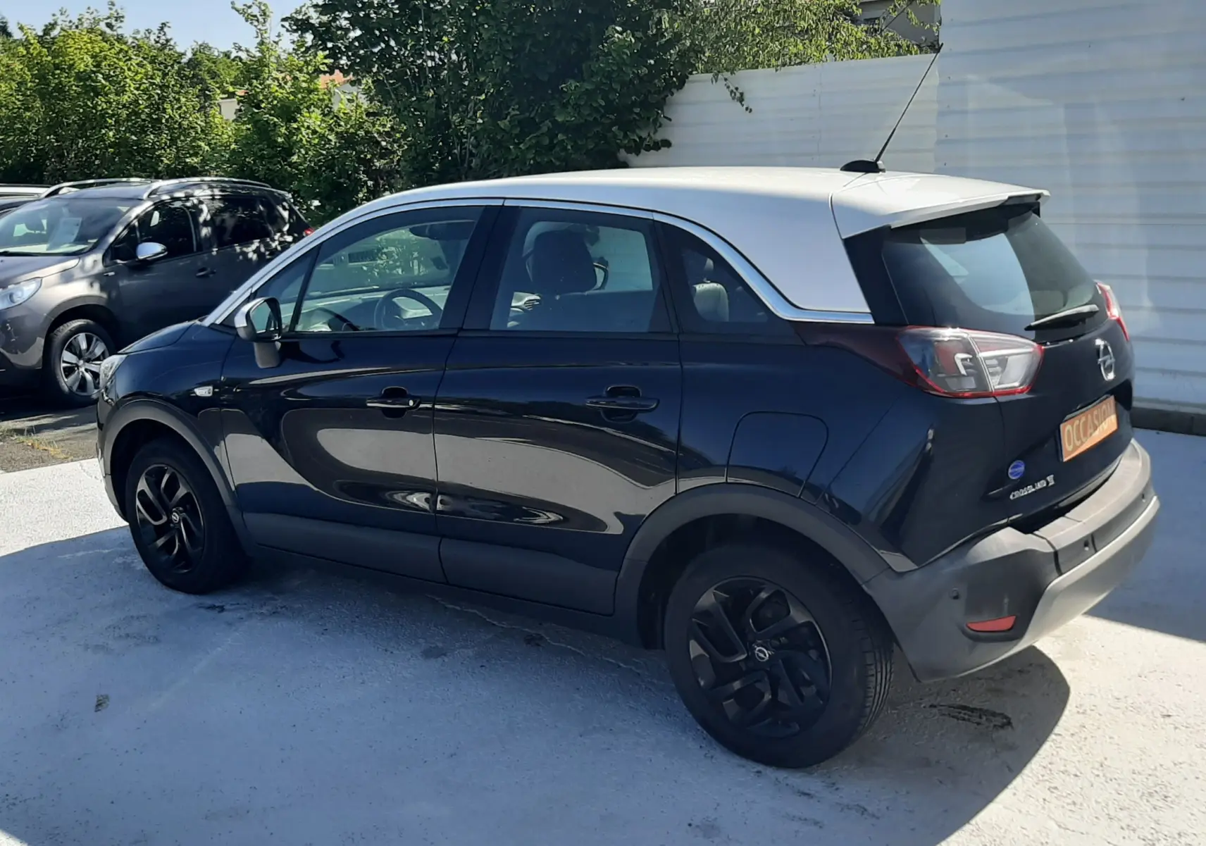 Pneu de secours noir en position verticale dans le coffre d'une Opel Crossland X 130ch Innovation 2019 noir toit blanc