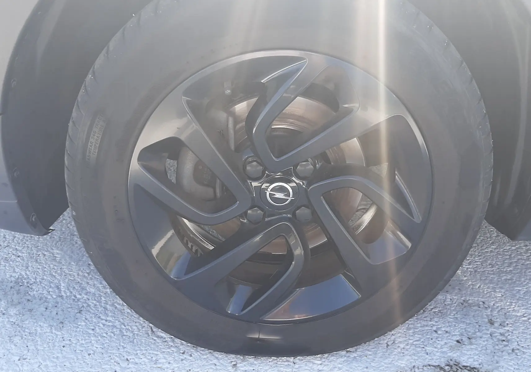 Gros plan sur le phare avant gauche d'une Opel Crossland noir avec toit blanc, mettant en valeur les détails du pare-chocs.