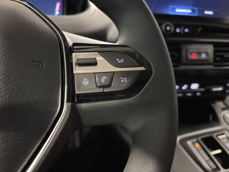 Gros plan sur les commandes multimédia au volant du Peugeot Partner XL BlueHDi 130ch, intérieur noir.