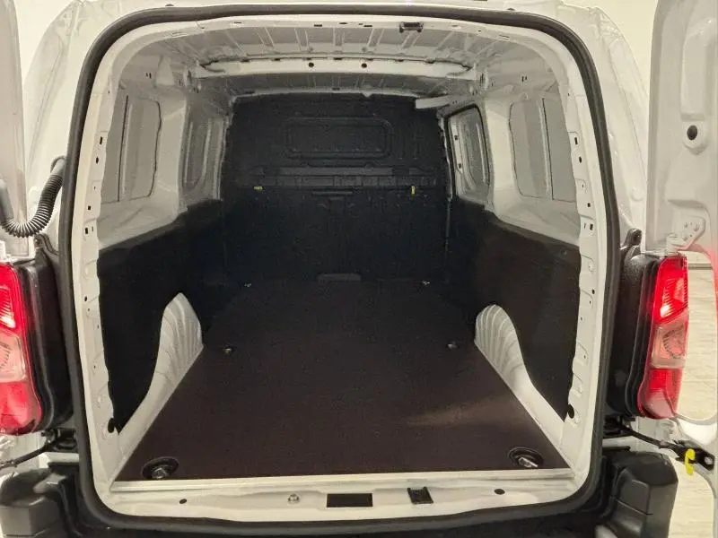 Vue arrière ouverte du coffre spacieux et vide du Peugeot Partner XL blanc Icy, soulignant son volume utilitaire.