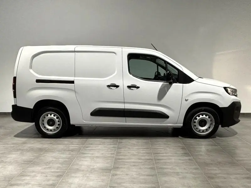 Vue de profil côté gauche d'un Peugeot Partner XL blanc Icy avec porte latérale coulissante et protections noires.