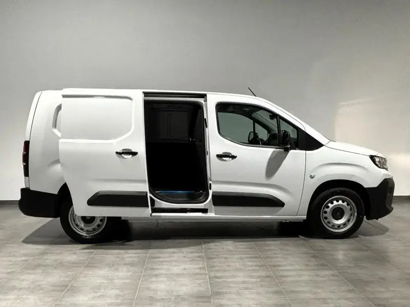 Vue latérale droite d'un Peugeot Partner blanc Icy avec porte coulissante ouverte sur un fond neutre.