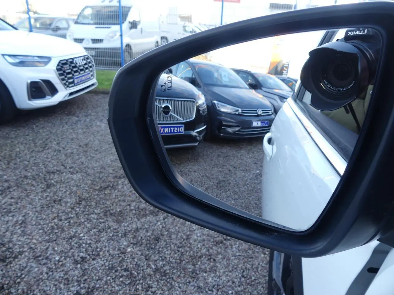 Rétroviseur côté droit d'un Peugeot 3008 blanc nacré, avec reflet de plusieurs voitures en arrière-plan.