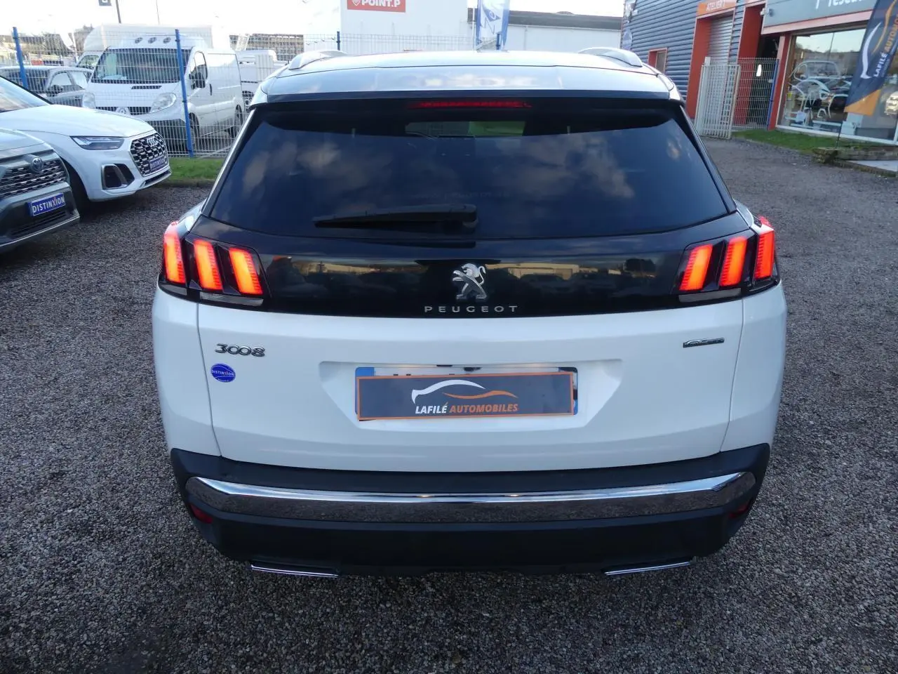 Vue arrière d'un Peugeot 3008 blanc nacré avec feux arrière à trois griffes et bandeau noir brillant.