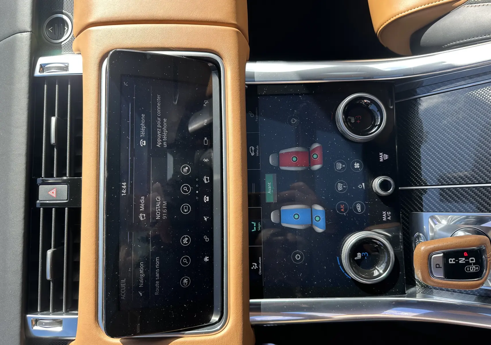 Vue rapprochée de la console centrale du Range Rover Sport gris foncé, avec écran tactile et levier de vitesse en cuir marron.