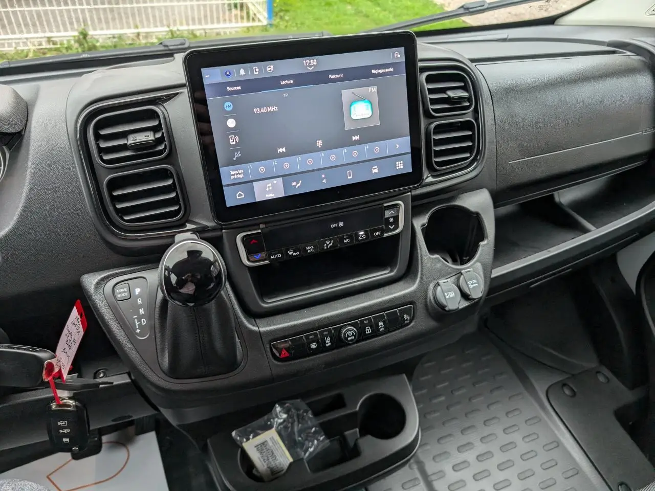 Vue rapprochée du tableau de bord noir du Citroën Jumper 2025, avec écran tactile 10 pouces et levier de boîte automatique.