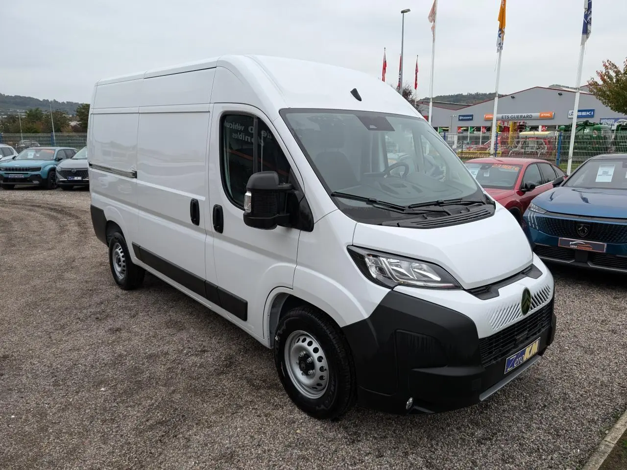 Vue 3/4 avant droite d'un utilitaire Citroën Jumper blanc avec pare-chocs noir et jantes acier 16 pouces.