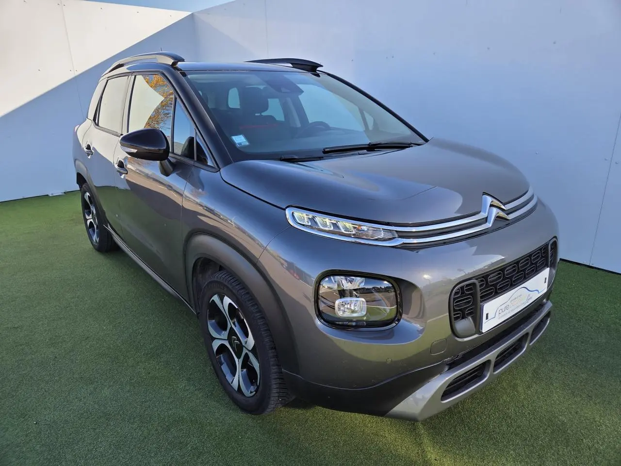 Citroën C3 Aircross gris platinium avec toit noir perlé, vue 3/4 avant droit, jantes alliage 17 pouces damantées.